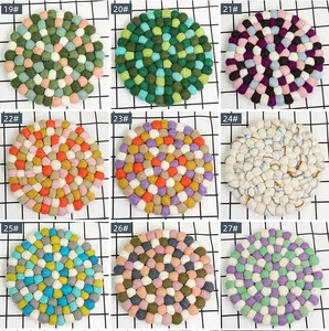 Detail view showing nine colorful felt ball coasters in various vibrant color palettes