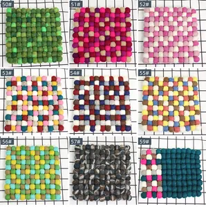 Macro detail of square handmade wool felt coasters in diverse colorful ball patterns