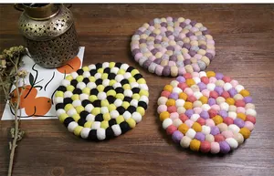 Macro view of thick handmade wool felt ball coasters in colorful mixed round patterns