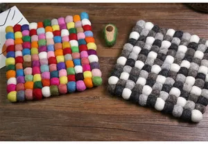 Close-up of square felt coasters in colorful and monochrome wool ball textures