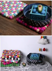 Close-up of colorful handmade wool felt ball coasters and heat-resistant square table mats