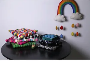Detailed texture of handmade square wool felt ball coasters in various colorful shades