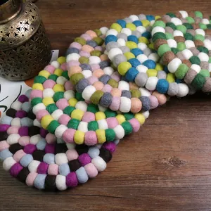 Handmade colorful wool felt ball coasters in a circular pattern for home table decor