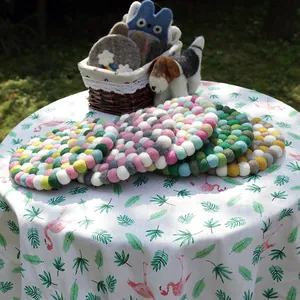 Handmade colorful wool felt ball coaster in a cozy outdoor Nordic style setting