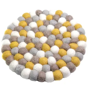 Handmade Nepal wool felt ball coaster in yellow, grey, and white colors for home decor
