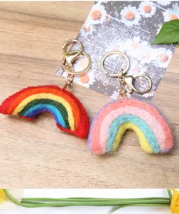 Macro detail of handmade wool felt rainbow keychains with gold metal lobster clasps