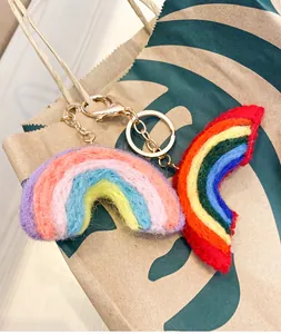 Detailed view of handmade rainbow wool felt charms on a bag with gold metal chains