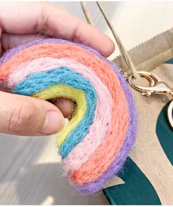 Detail of a colorful handmade wool felt rainbow keychain with a golden metal clasp