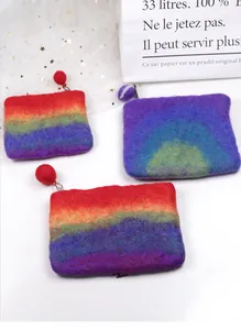 Detail of handmade rainbow wool felt coin purses with fuzzy pompoms and metal zippers