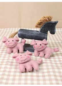 Close-up of handmade pink wool felt pig brooches with detailed stitching and cute design