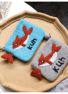 Close-up of handmade blue and grey wool felt coin purses with fish and kun embroidery