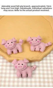 Handmade pink wool felt pig brooches with size labels 10cm x 7cm on ceramic plate