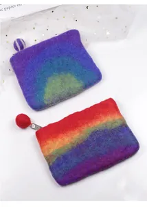 Close-up of handmade rainbow wool felt coin purses with zipper and wool ball charm
