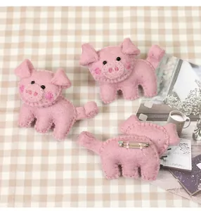 Handmade pink wool felt pig brooch set showing detailed texture and metal safety pin