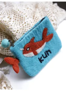 Close-up of handmade blue wool felt coin purse with embroidered fish and kun letter