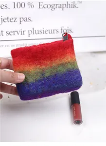 Handheld view of a colorful rainbow striped wool felt coin purse with a black zipper