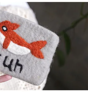 Detailed texture of handmade wool felt coin purse with cute orange animal pattern