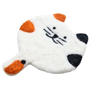 Handmade wool felt calico cat coaster with cute embroidery details on white background