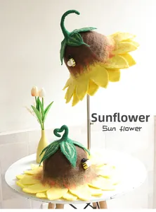 Detailed view of handmade wool felt sunflower hats with bee accent and green leaves