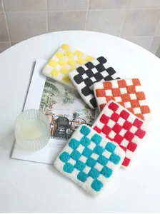 Detailed close-up of handmade checkered wool felt coasters in various vibrant colors