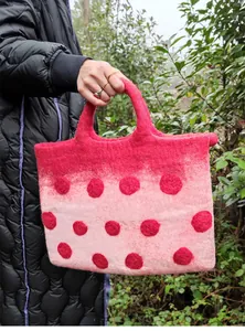 Detail of wool felt tote bag with 3D red dots and pink gradient textured surface