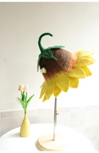 Detail of wool felt sunflower hat with petals and a cute bee accent on a stand