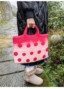 Detail of pink ombre wool felt tote bag with red polka dots and thick texture handle