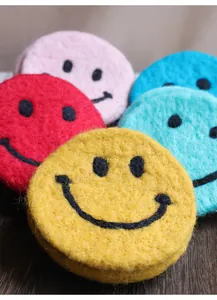 Detailed close-up of colorful felt smiley face coasters with high-quality embroidery