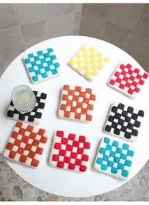 Close-up of colorful checkered wool felt coasters with thick hand-woven texture and vibrant colors