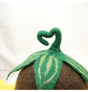 Close-up of wool felt flower hat with detailed green leaf and heart-shaped sprout