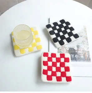 Detail view of square wool felt coasters with colorful checkerboard pattern and soft texture