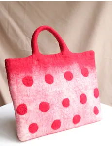 Detailed macro view of pink gradient wool felt tote bag with large red polka dots texture