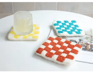 Detail shot of colorful checkered wool felt coasters showing thick texture and soft fiber