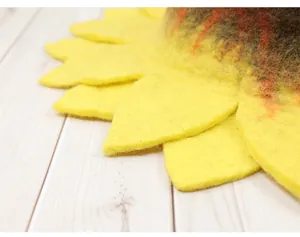 Close-up of wool felt sunflower hat petals showing handmade fiber texture and yellow color