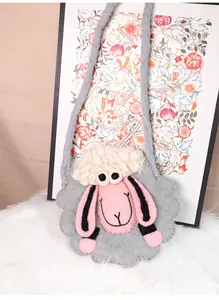 Détail d'un sac bandoulière en feutre de mouton fait main sur un tapis moelleux