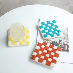 Minimalist wool felt checkerboard coasters in yellow, blue, and red for heat insulation