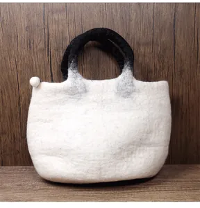 Detail of wool felt tote bag showing fuzzy white texture and black gradient handles