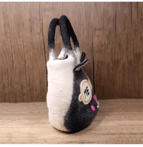 Detail of wool felt cat handbag showing gray patchwork texture and cat ear accents