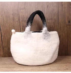 Detail of wool felt tote bag showing off-white texture and black gradient handles
