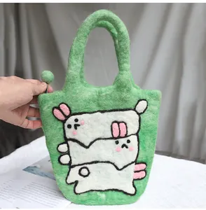 Close-up of green wool felt bag featuring white cartoon bear patterns and soft texture