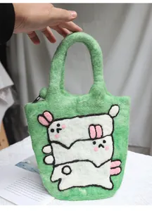Detail of green handmade wool felt handbag with cute white rabbit patterns and zipper