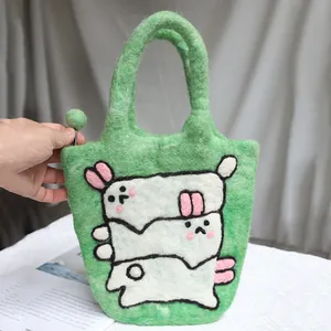 Handmade wool felt rabbit handbag in grass green featuring cute white cartoon bunnies