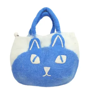 Detail of wool felt cat tote bag with handmade embroidery and decorative white puff pendant