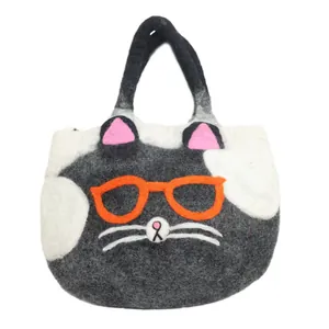 Close-up of a handmade cat-shaped wool felt tote bag with 3D embroidery details