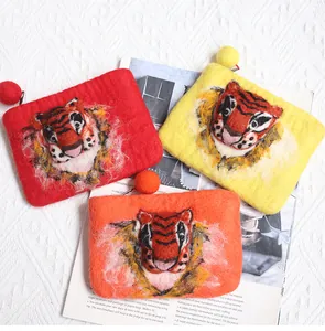 Detailed macro view of handmade 3D wool felt tiger pouches in red, yellow and orange colors