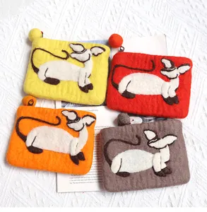 Macro shot of colorful wool felt cat wallets with zipper closure and pompom detail