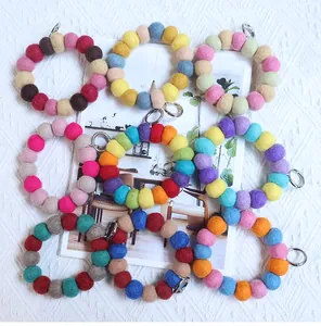 Close-up of colorful handmade wool felt ball ring pendants with metal spring buckles
