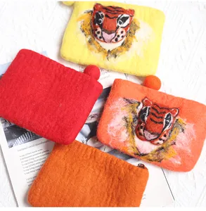 Detailed close-up of handmade felt tiger head coin purses with soft wool texture and zippers