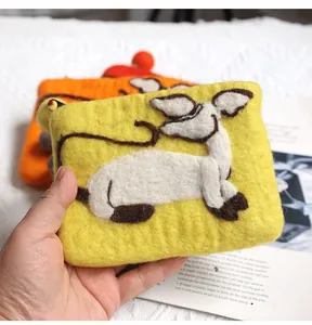 Detailed texture of handmade wool felt coin purse featuring cute 3D sheep and red pompom
