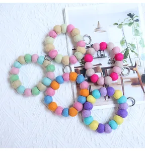 Macro detail of colorful handmade wool felt ball keychain wristlet with silver metal clasp